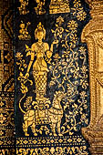 Wat Xieng Thong temple in Luang Prabang, Laos. The facade of the sim decorated with gold stencilling on a black lacquer background. 